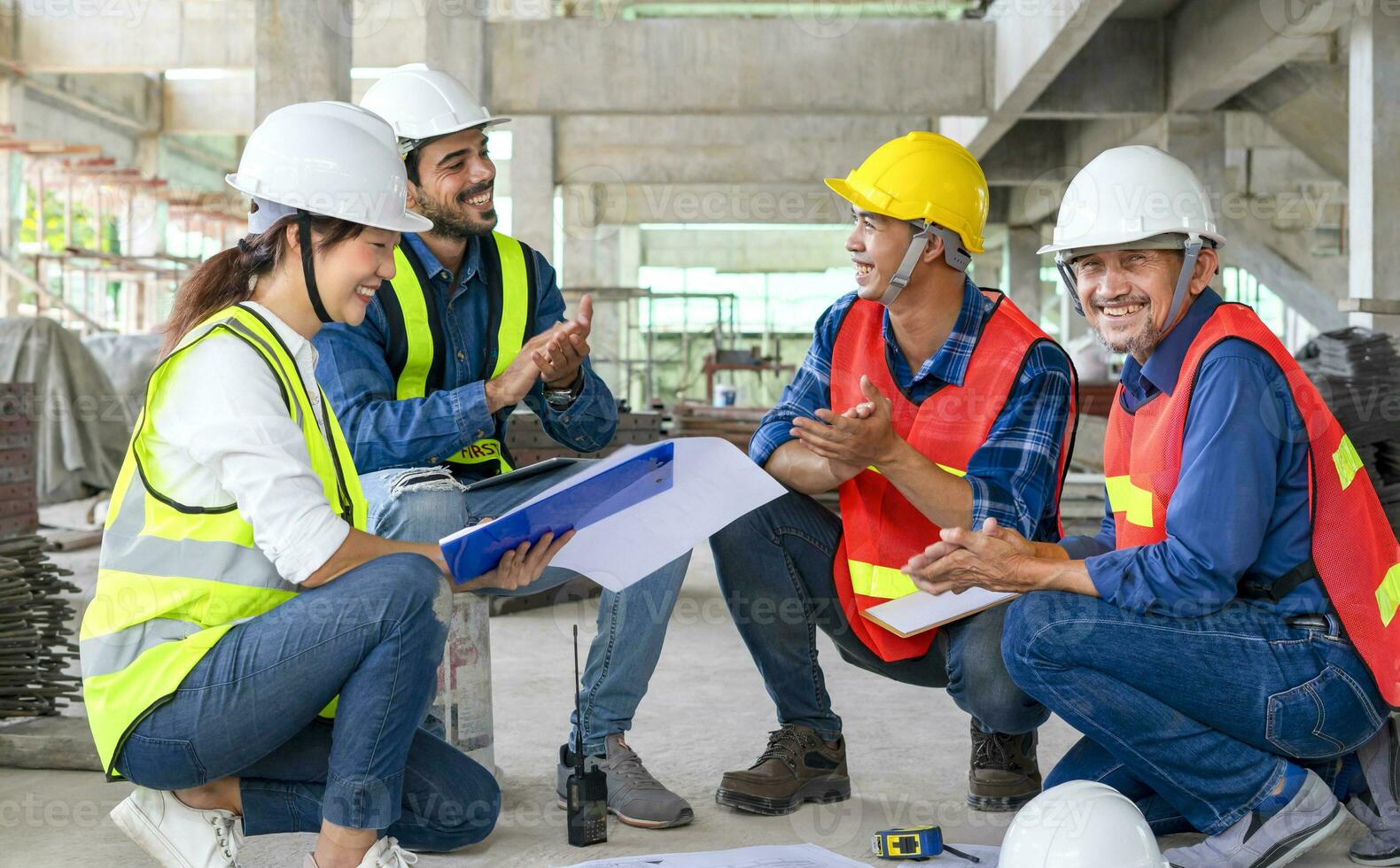 happy engineering team applaud during sitting on floor and meeting at the new building under construction, successful engineers teamwork working on site photo