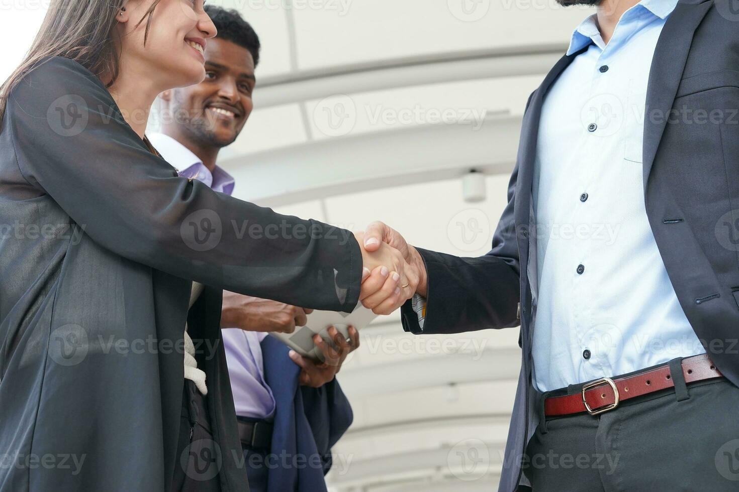 two business people shaking hands to greet each other photo