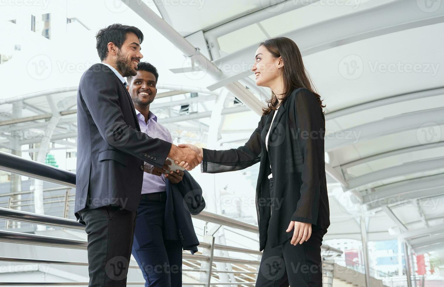 diverse business people greeting outside office, businessman doing handshake with businesswoman for successful dealing photo