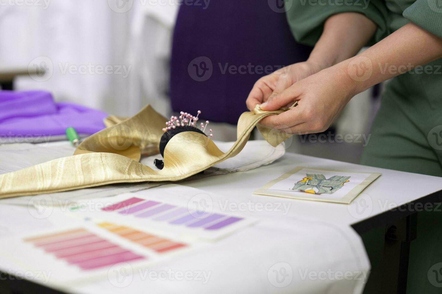 woman hands place a pin into the fabric to hold it in place to sew the collar,concept of business,industrial,occupation,hobby,craft,sewing,tailoring photo
