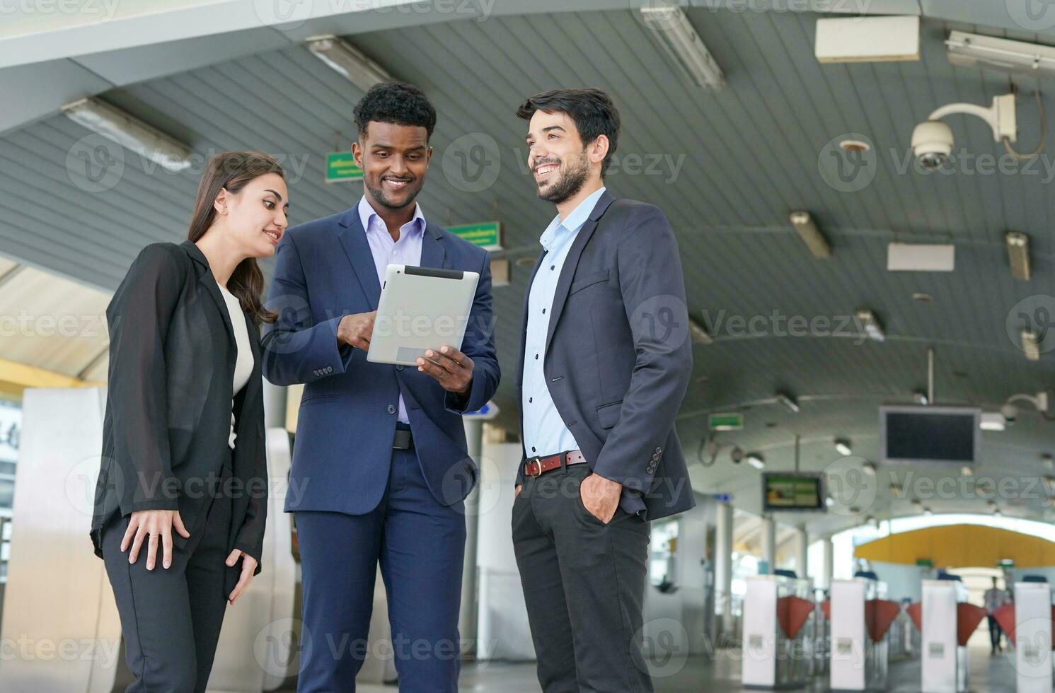 business inspectors using tablet and talking about business together in front of skytrain fare gates photo