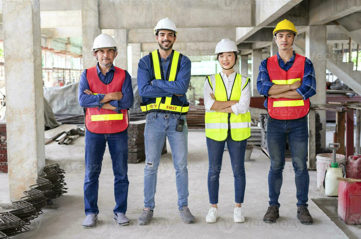 engineering teamwork in full safety gear,standing arms crossed,in the building under construction that filled with many construction equipment.concept of engineering work,engineer working on site work photo