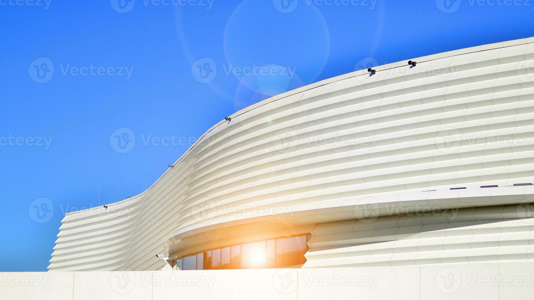 Minimalist photo of an exterior of a modern tin building with big glass showcases.