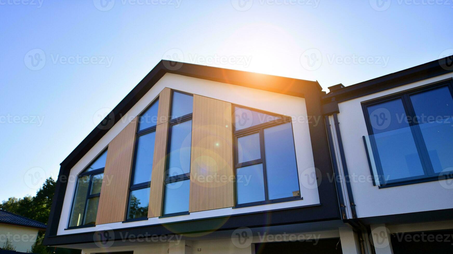 Suburban neighborhood with condominium complex. Suburban area with modern geometric family houses. Row of family houses against blue sky. photo