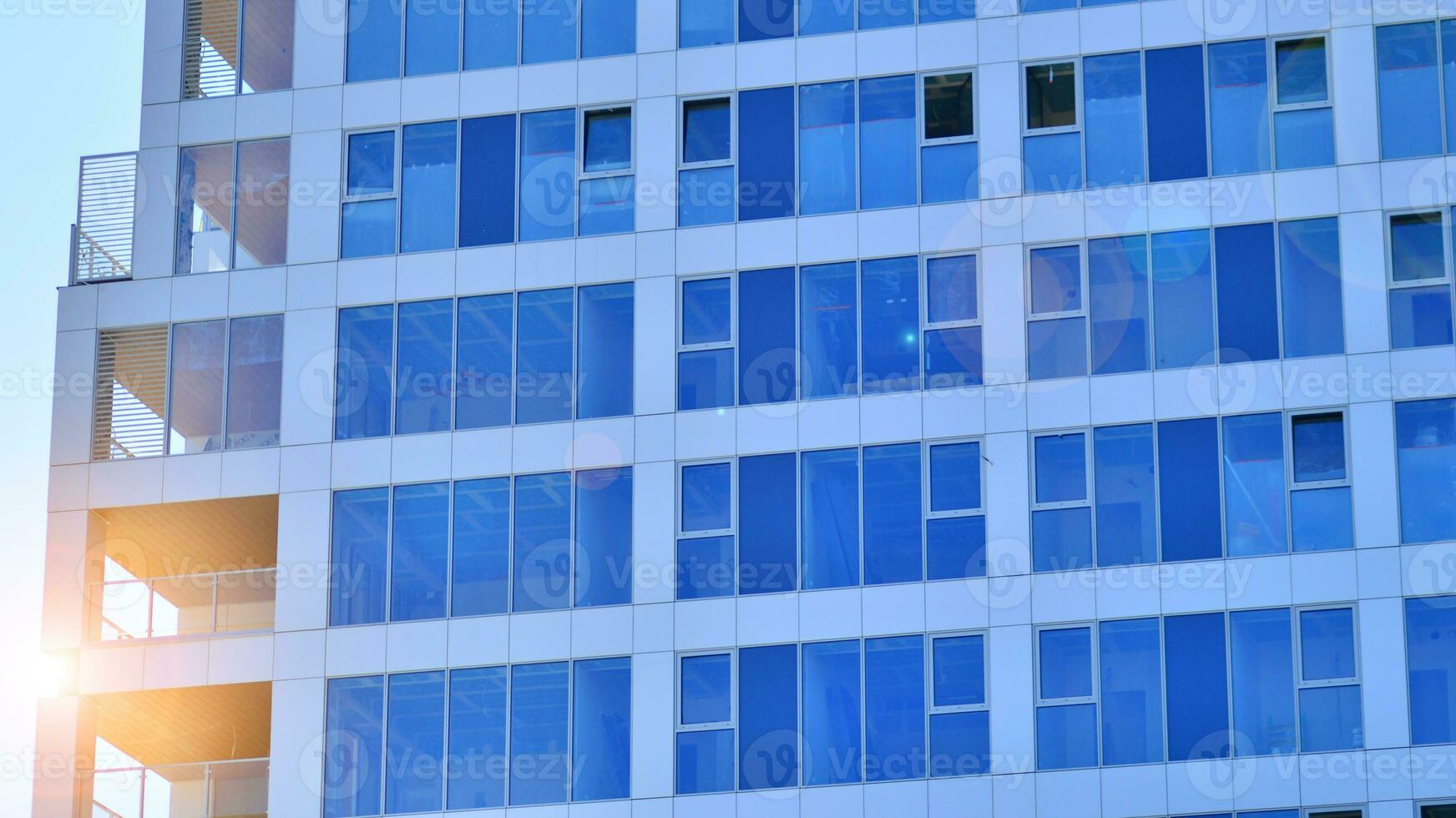 Exterior of a high modern multi-story apartment building - facade, windows and balconies. photo