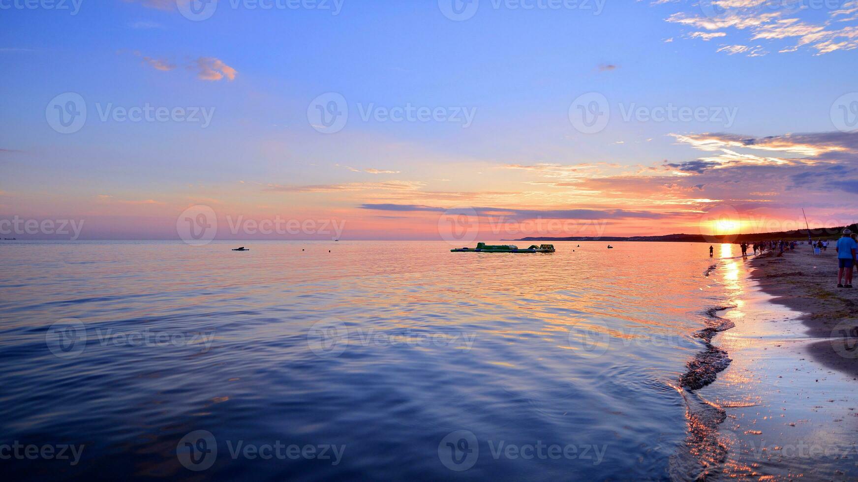 A summer sunset scenery on the horizon. Sea in golden colors and amazing clouds on sky. photo