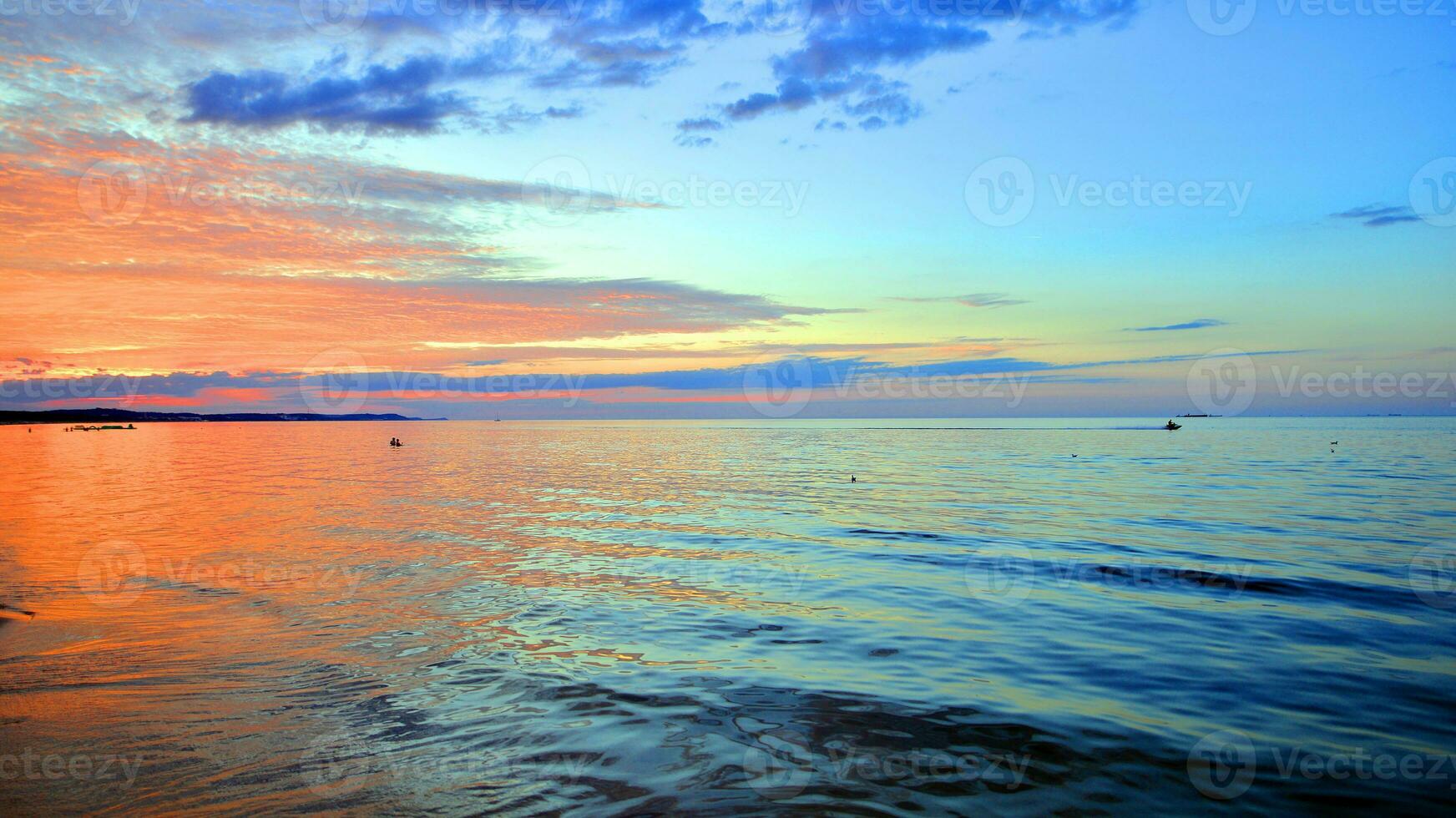 A summer sunset scenery on the horizon. Sea in golden colors and amazing clouds on sky. photo