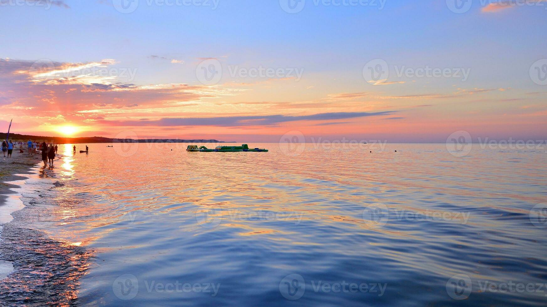 A summer sunset scenery on the horizon. Sea in golden colors and amazing clouds on sky. photo