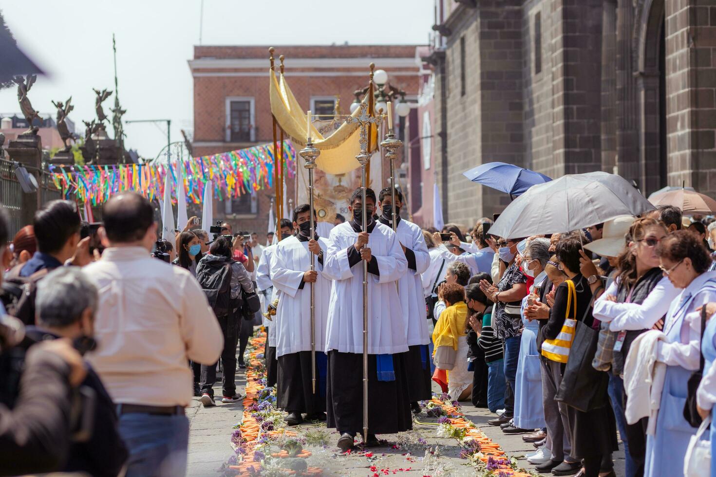 Puebla, Mexico 2023 - Priests and members of the Catholic Church carry out a procession in front of the Cathedral of Puebla. Worship of Catholic Christian symbols photo