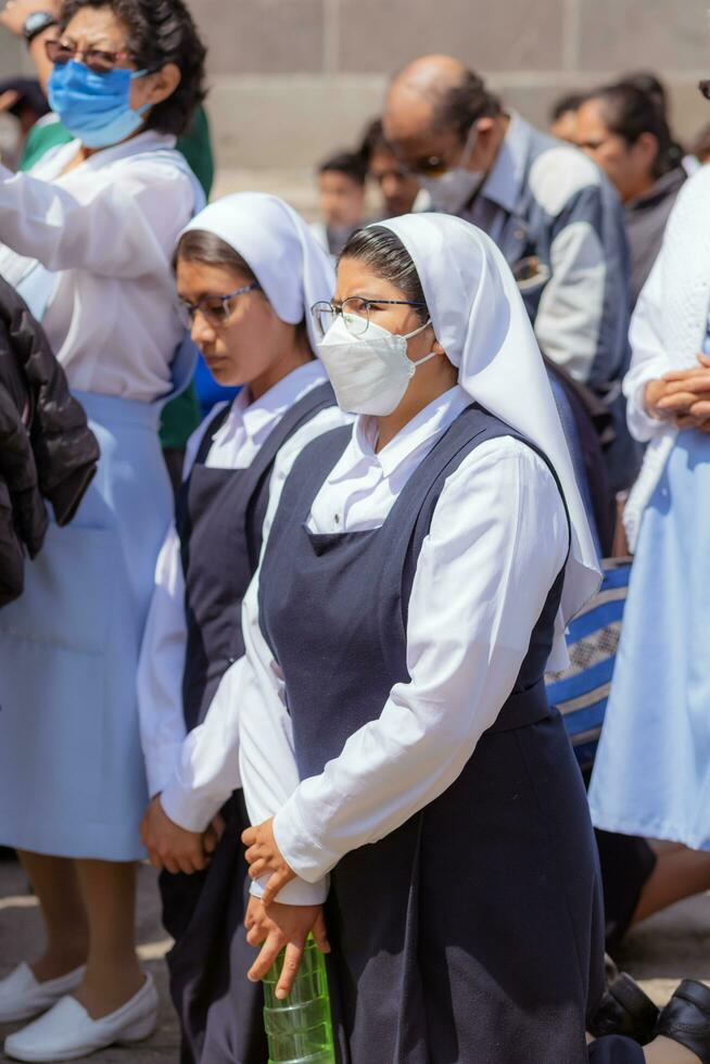 Puebla, Mexico 2023 - Priests and members of the Catholic Church carry out a procession in front of the Cathedral of Puebla. Worship of Catholic Christian symbols photo