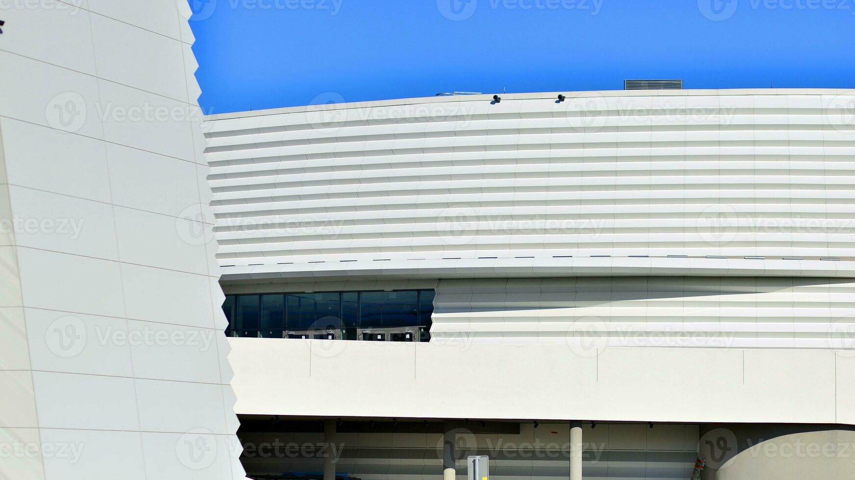 Minimalist photo of an exterior of a modern tin building with big glass showcases.