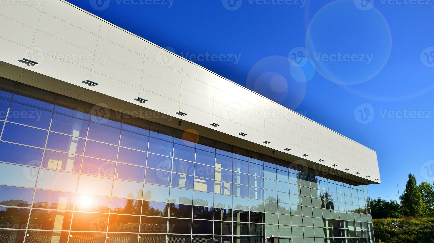 Minimalist photo of an exterior of a modern tin building with big glass showcases.