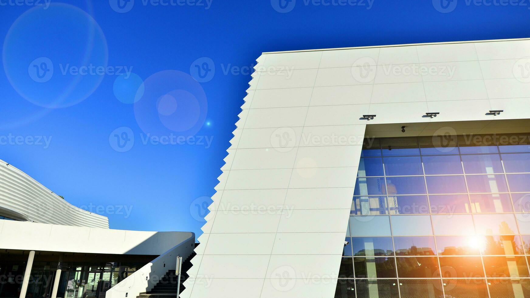 Minimalist photo of an exterior of a modern tin building with big glass showcases.