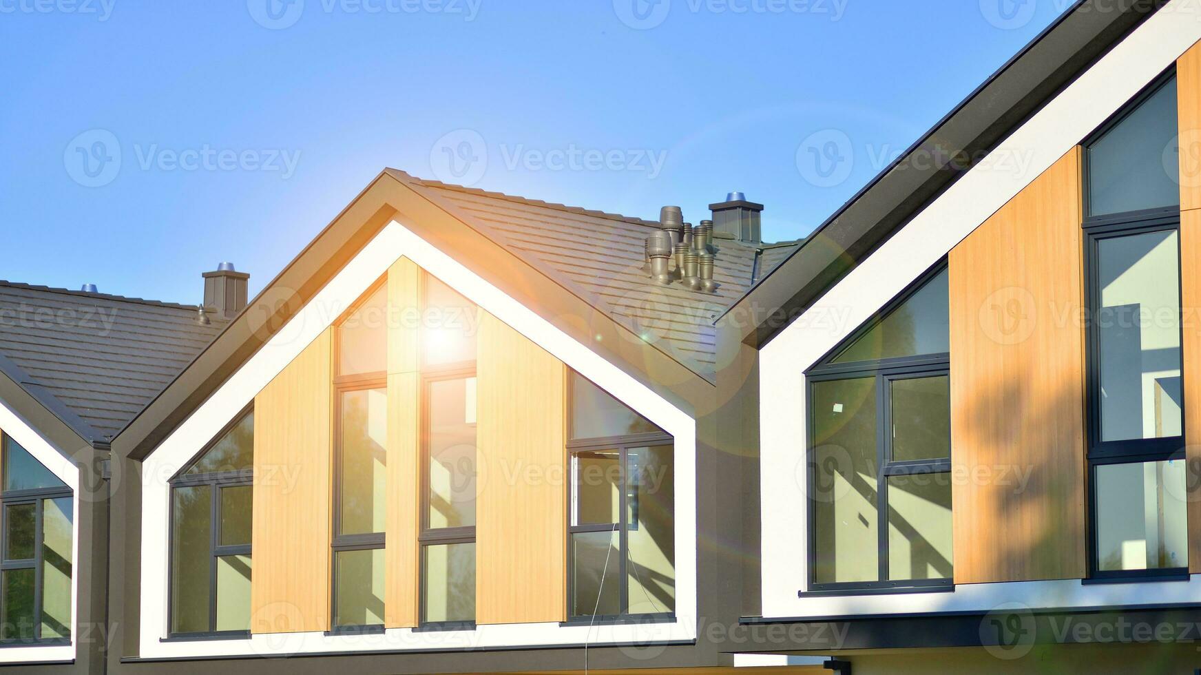 Suburban neighborhood with condominium complex. Suburban area with modern geometric family houses. Row of family houses against blue sky. photo