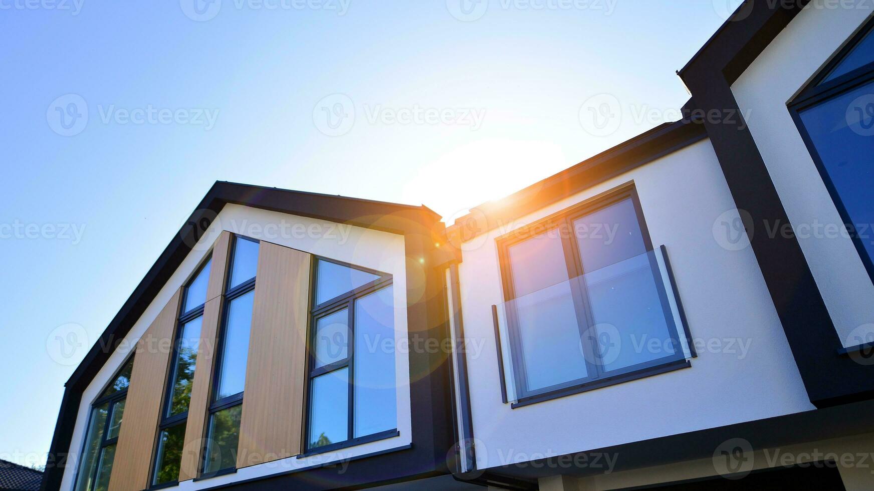 Suburban neighborhood with condominium complex. Suburban area with modern geometric family houses. Row of family houses against blue sky. photo