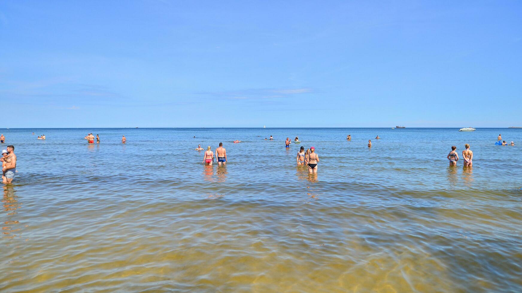 Swinoujscie, Poland. 15 August 2023. People in the water on the beach during holiday season in over Baltic Sea. photo