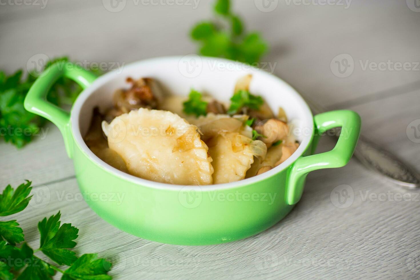 Potato dumplings with onion and mushrooms in a plate. photo