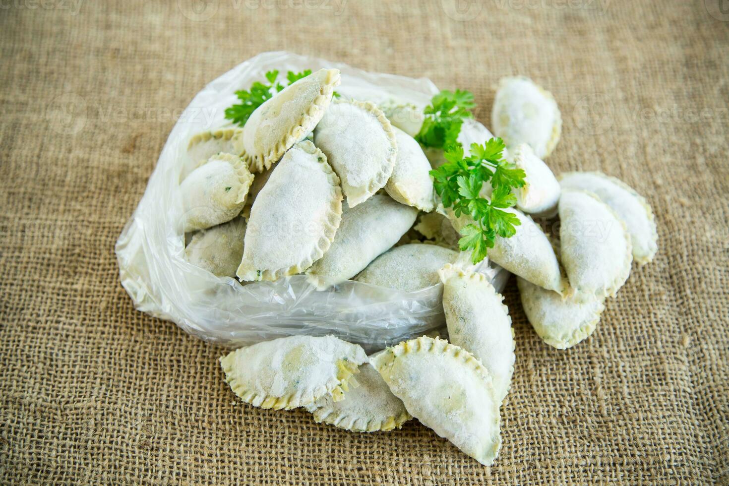 Raw green dough dumplings with parsley, dill. photo