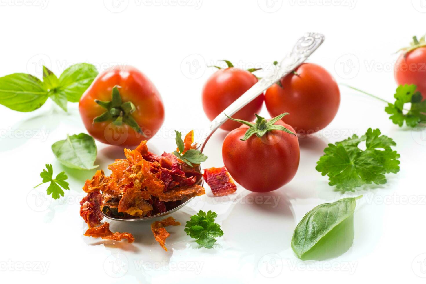 small pieces of dried tomatoes next to fresh tomatoes photo