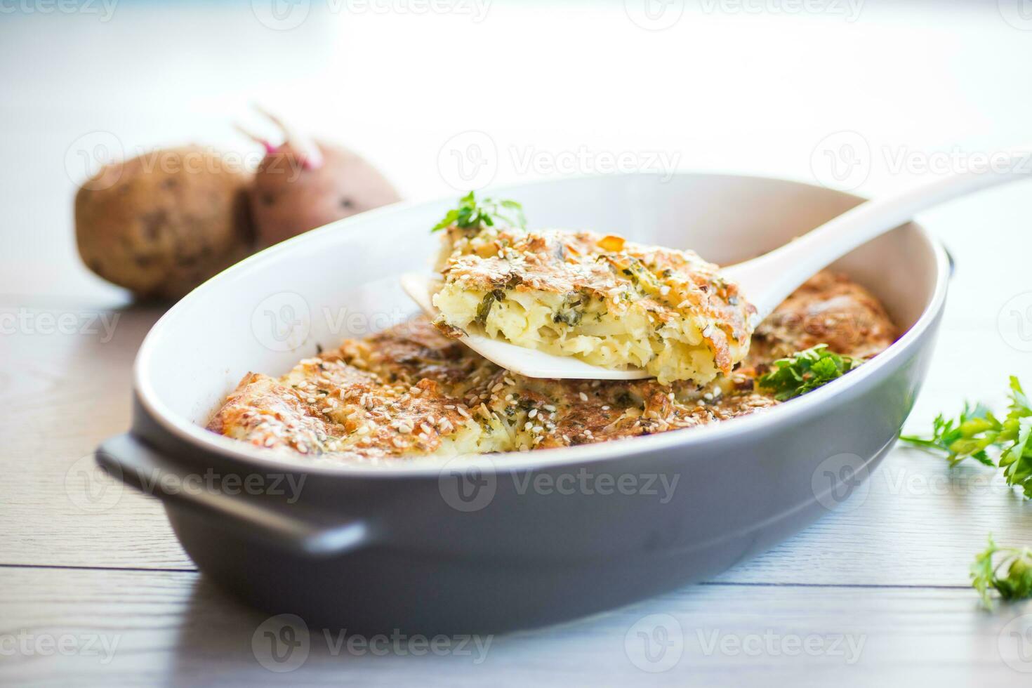 potato casserole with cabbage and spices in a ceramic form photo