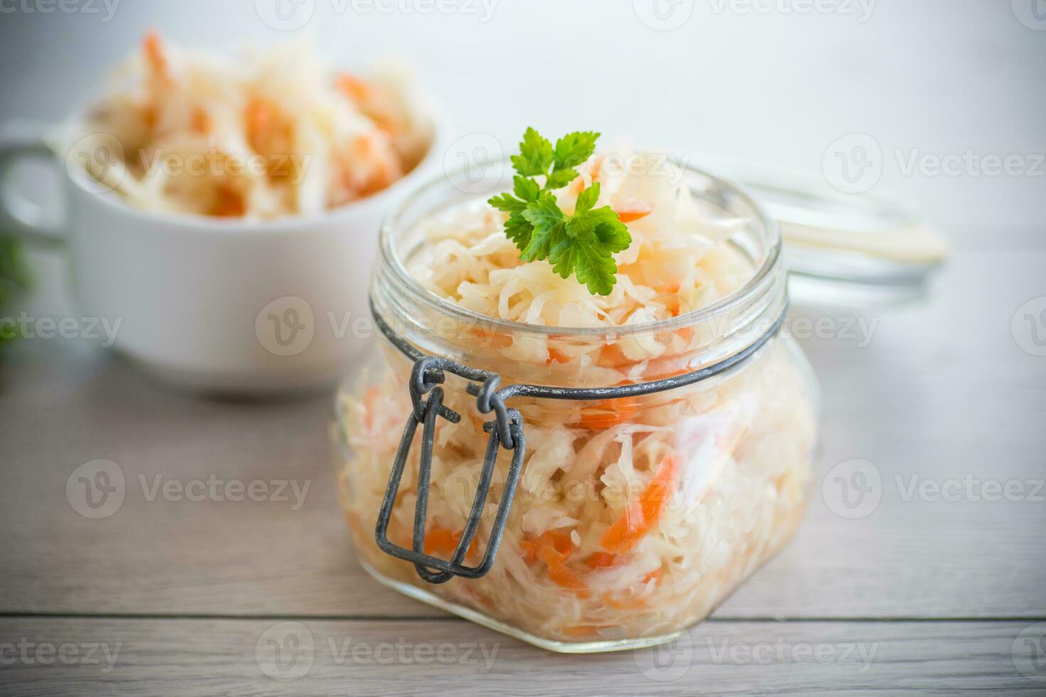 Sauerkraut with carrots and spices in a glass jar photo