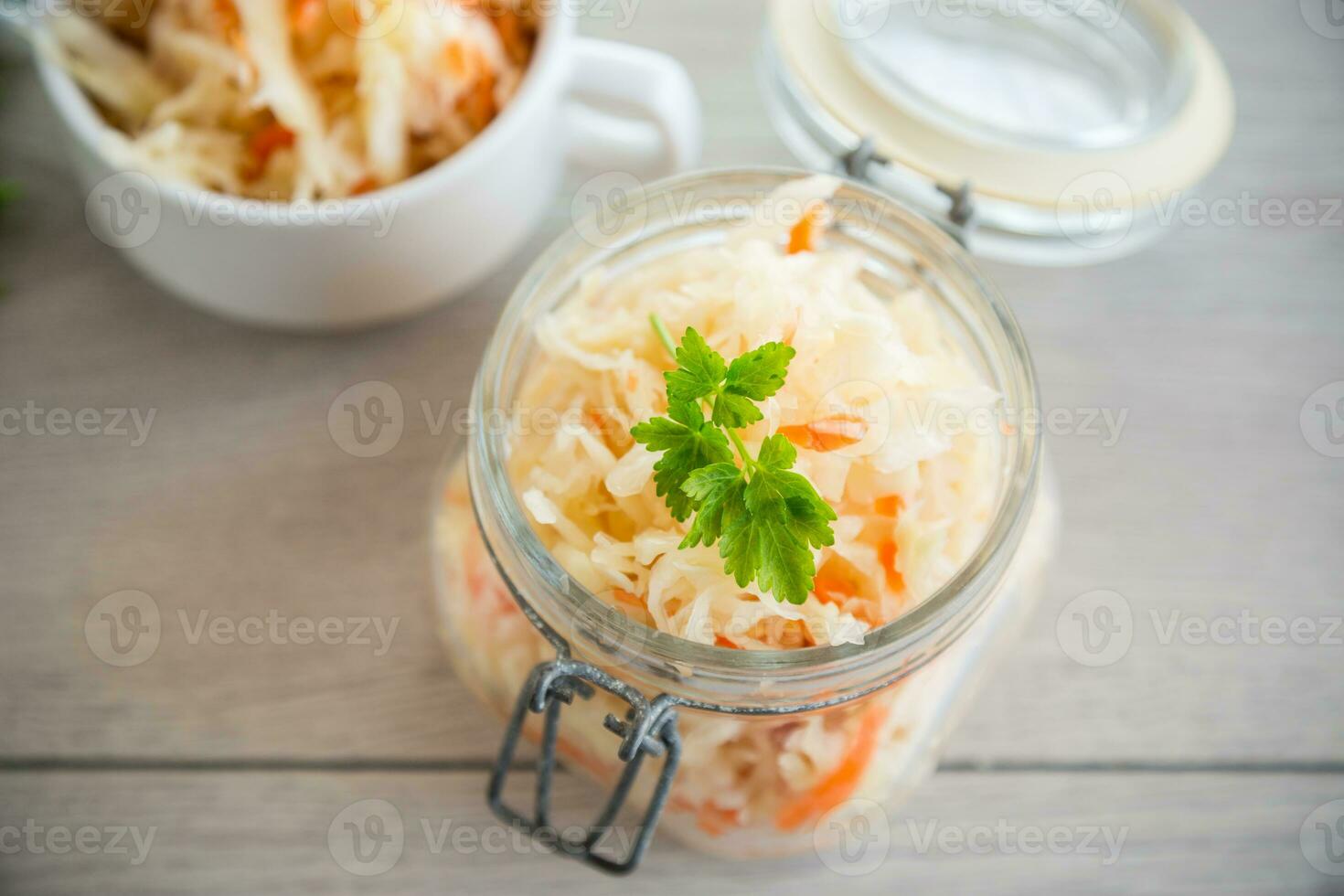 Sauerkraut with carrots and spices in a glass jar photo
