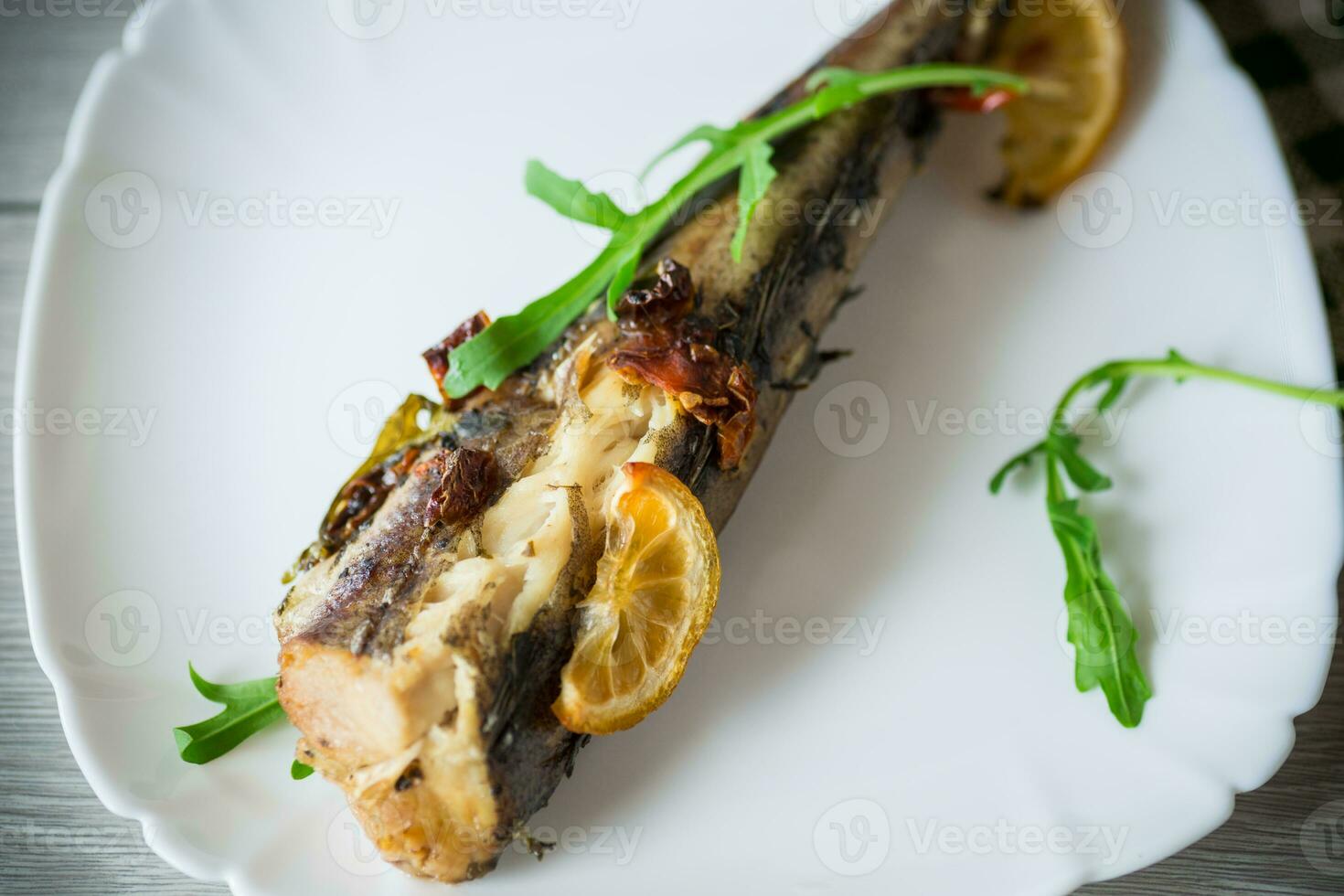 horneado pescado con condimentos y especias en un plato foto