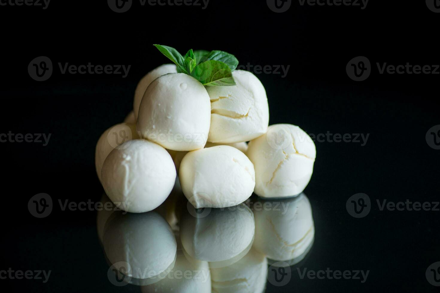 pequeño pelotas de tradicional queso Mozzarella en un cerámico cuenco foto