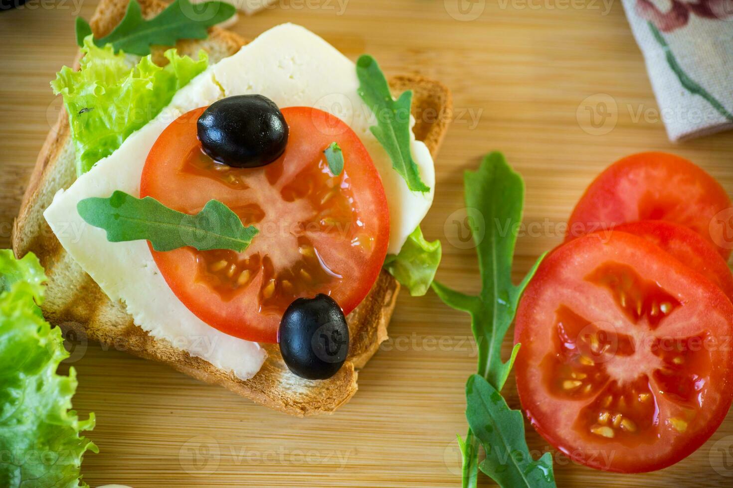 fried toasts with mozzarella, lettuce and tomatoes with herbs photo