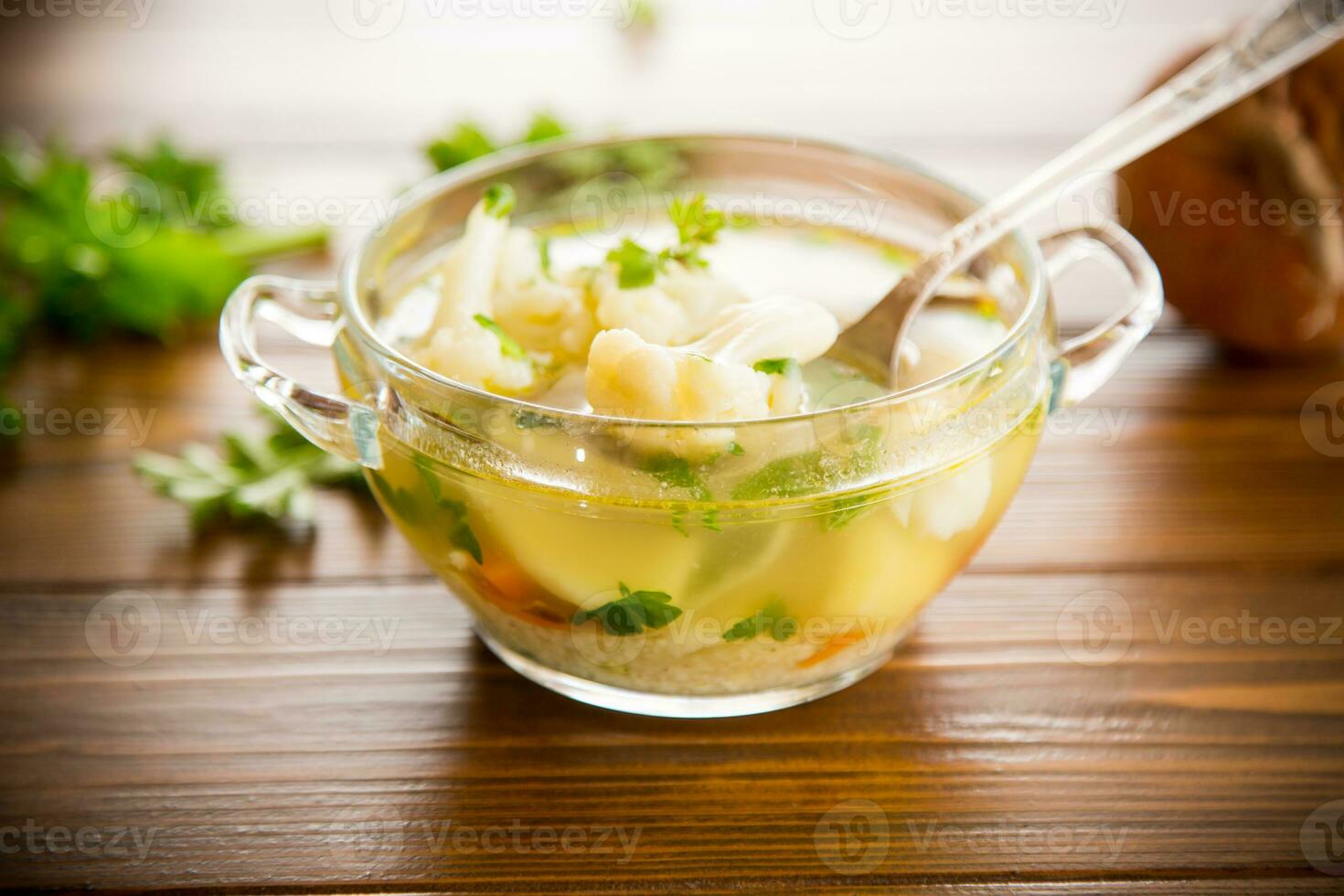 cooked chicken soup with cauliflower and vegetables in a bowl photo