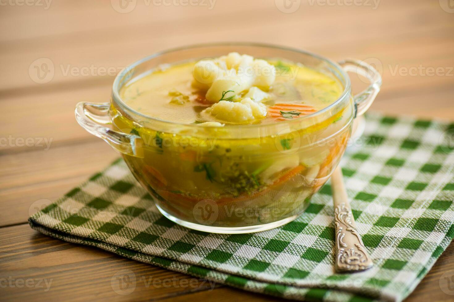 cooked chicken soup with cauliflower and vegetables in a bowl photo