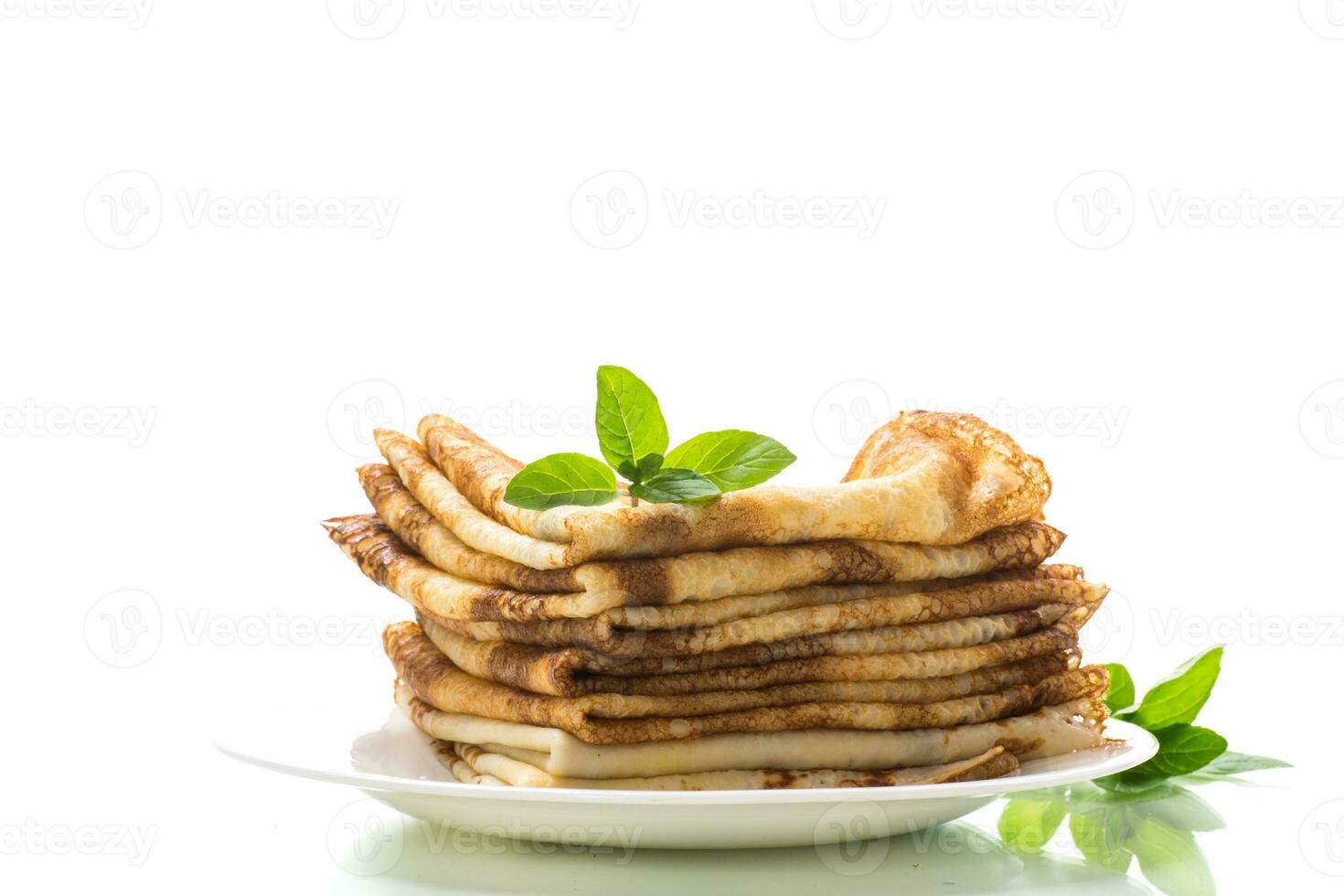 lot of pancakes thin pancakes in a plate, on white background. photo