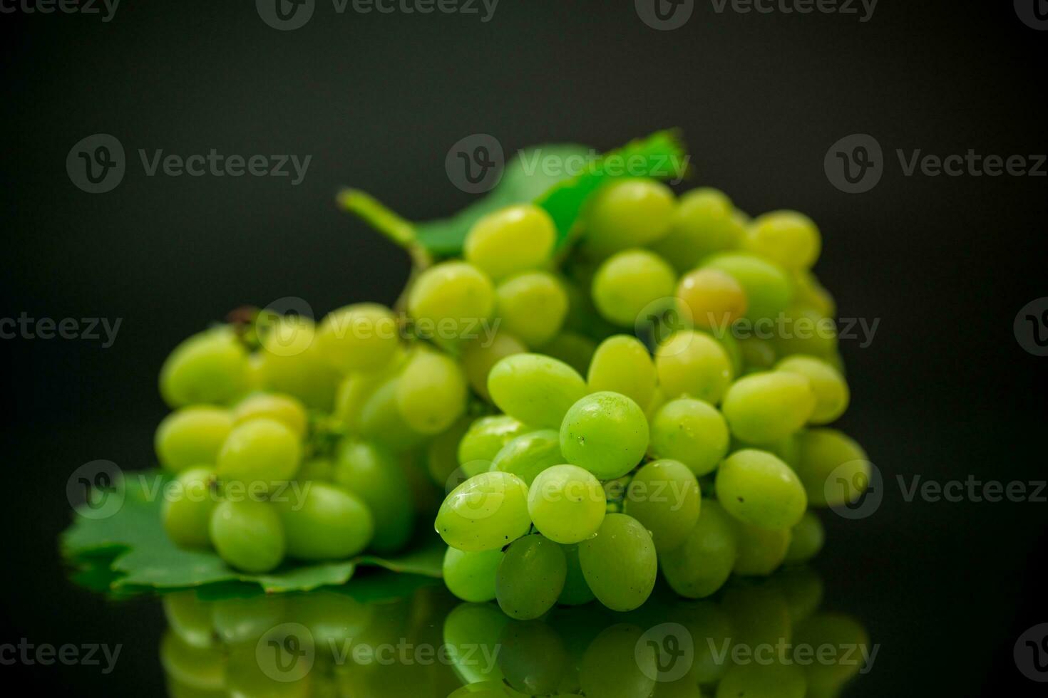 A bunch of ripe green grapes with leaves. photo