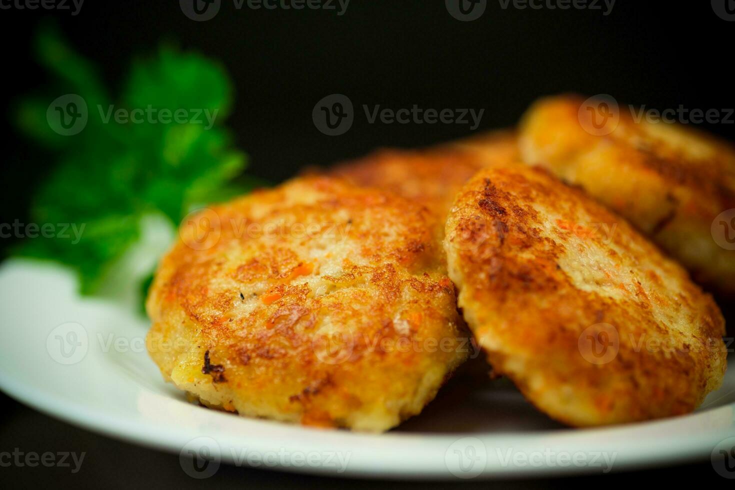 Cooked fried fish cutlets in a plate with herbs. photo