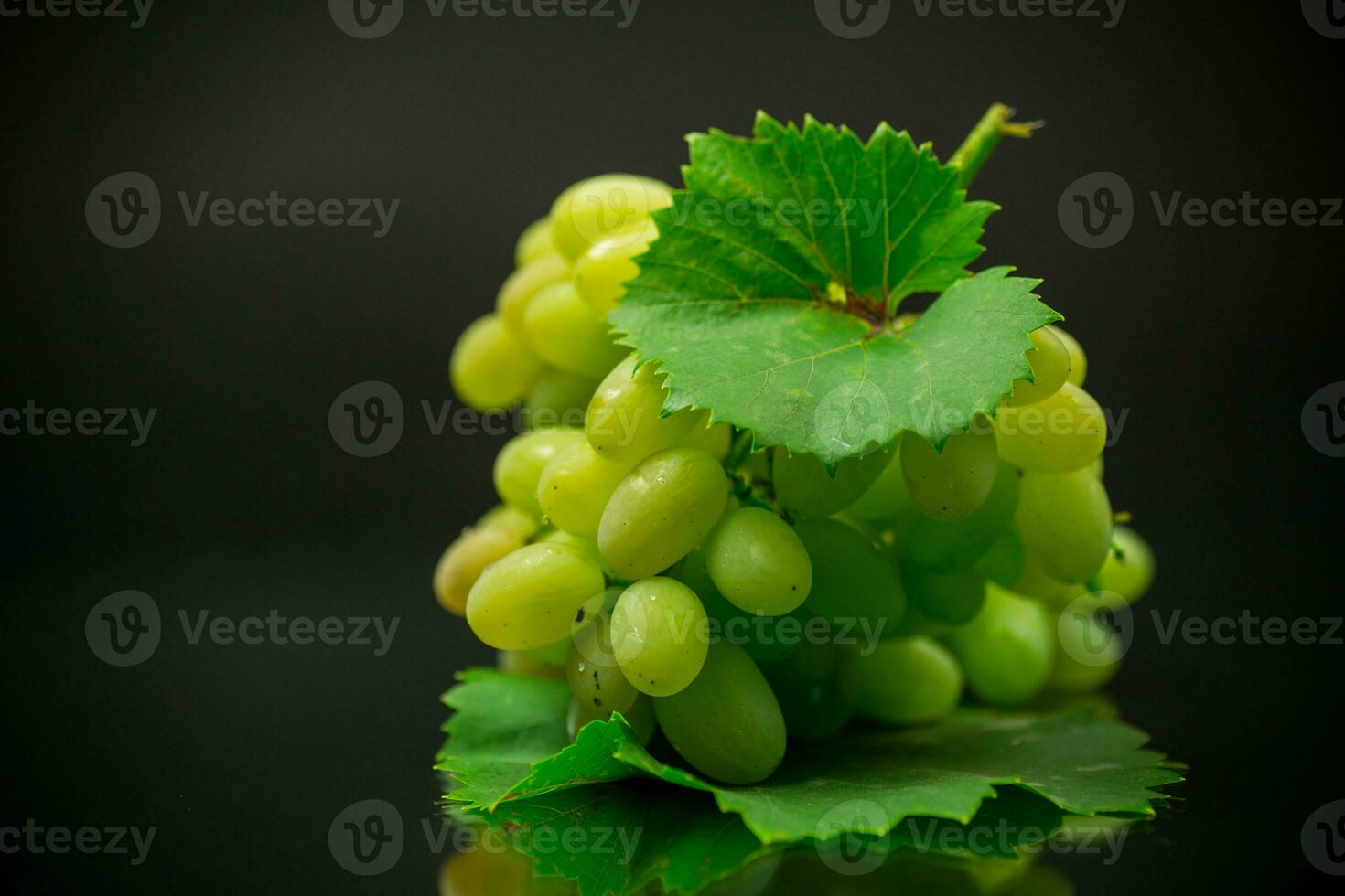 un manojo de maduro verde uvas con hojas. foto
