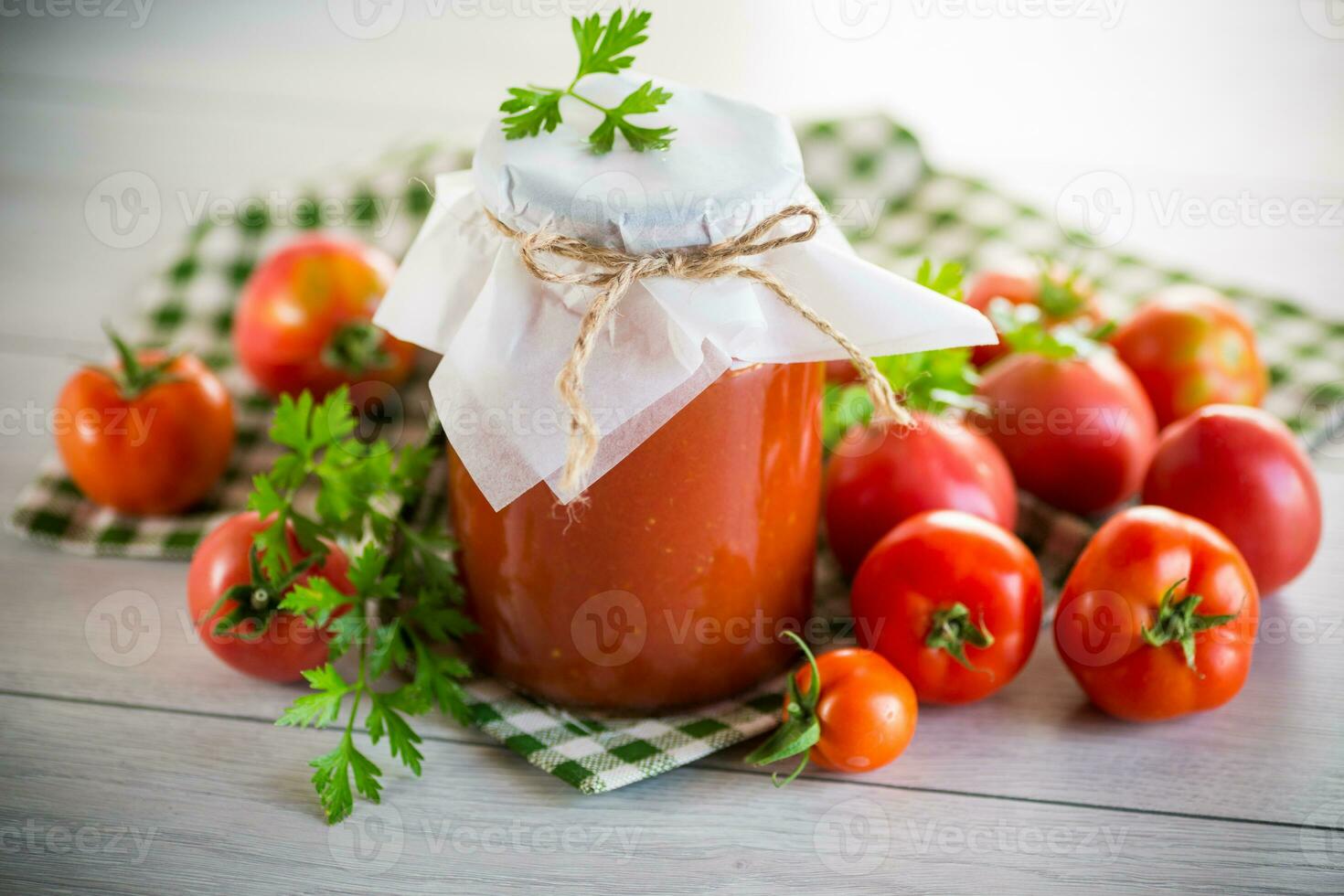 Cooked homemade tomato juice canned in a jar of natural tomatoes. photo