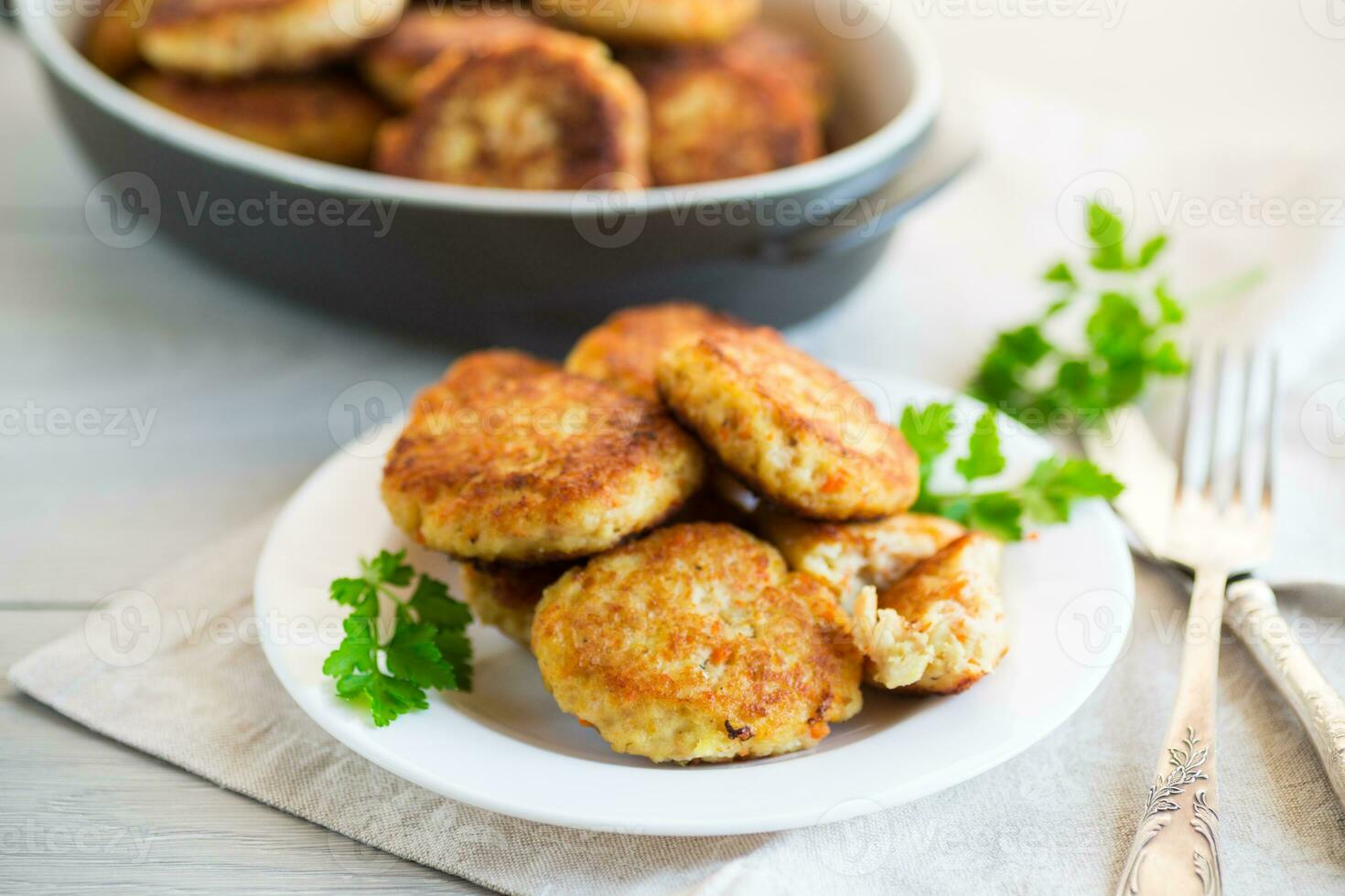 Cooked fried fish cutlets in a plate with herbs. photo