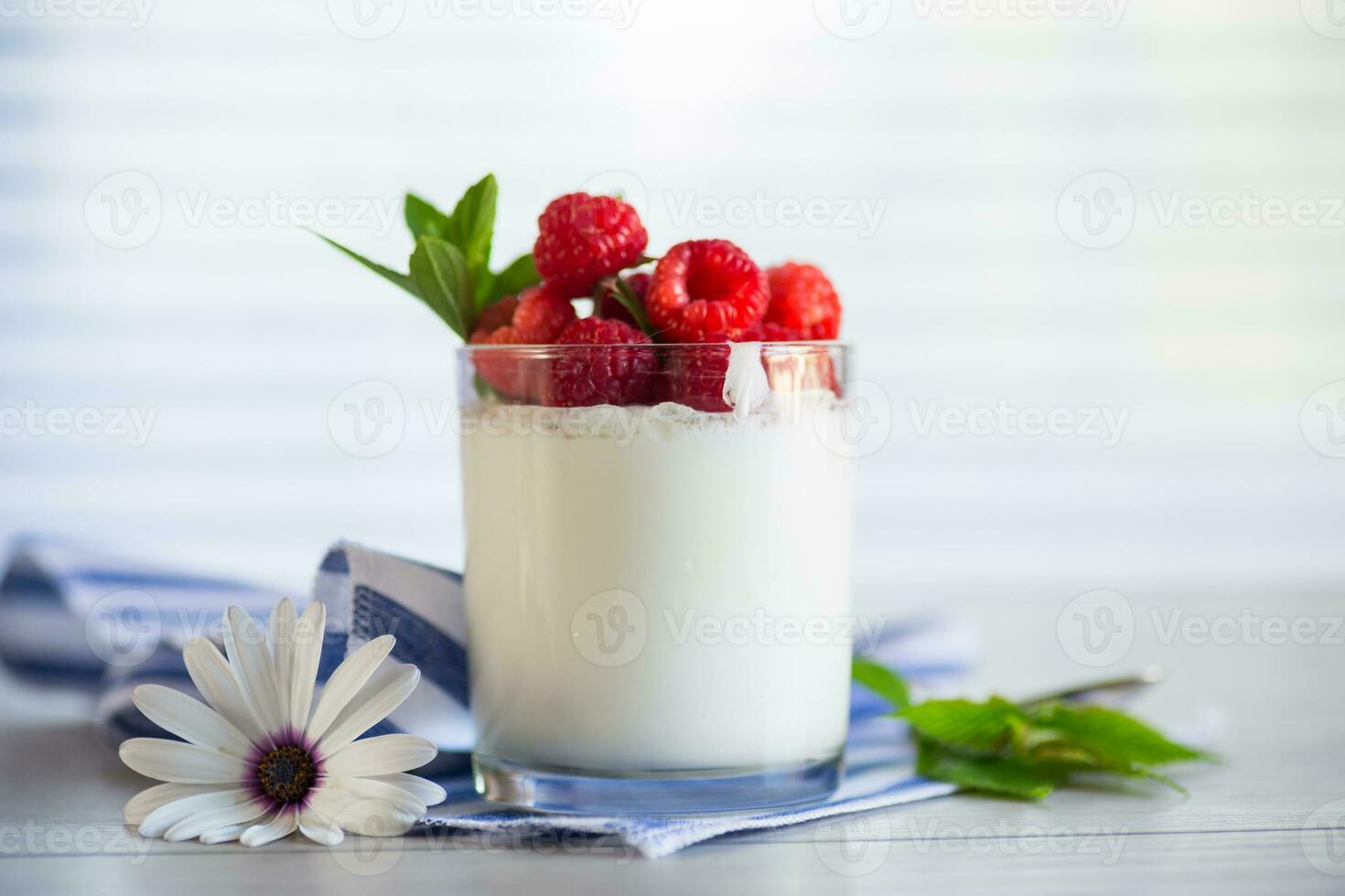 Sweet cooked homemade yogurt with fresh raspberries in a glass. photo