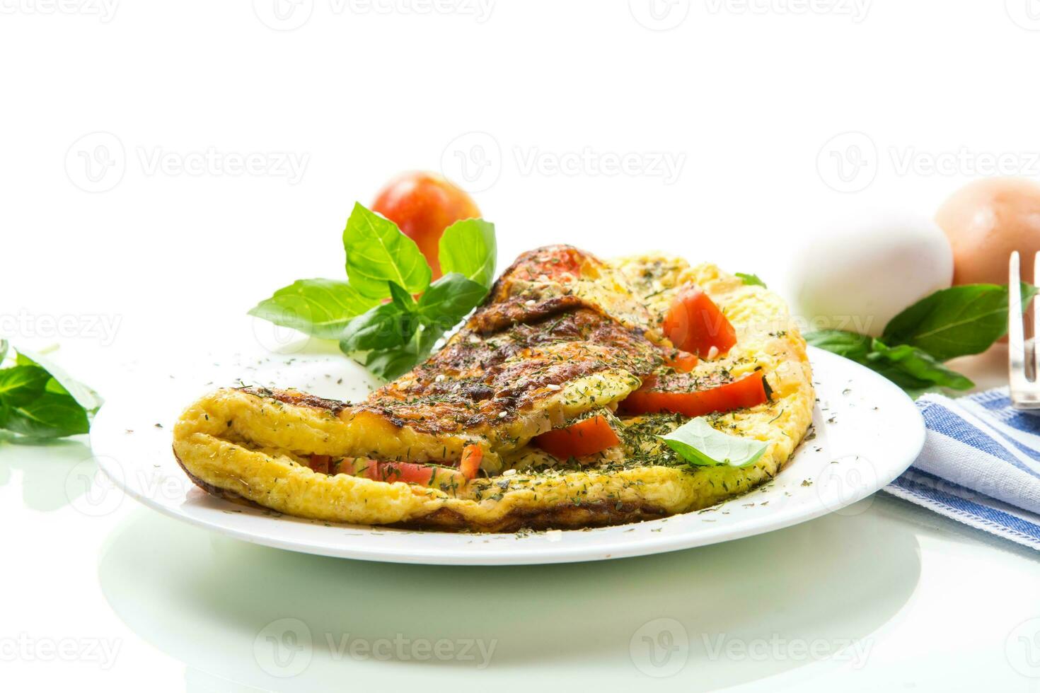 Stuffed omelette with tomatoes isolated on white background. photo