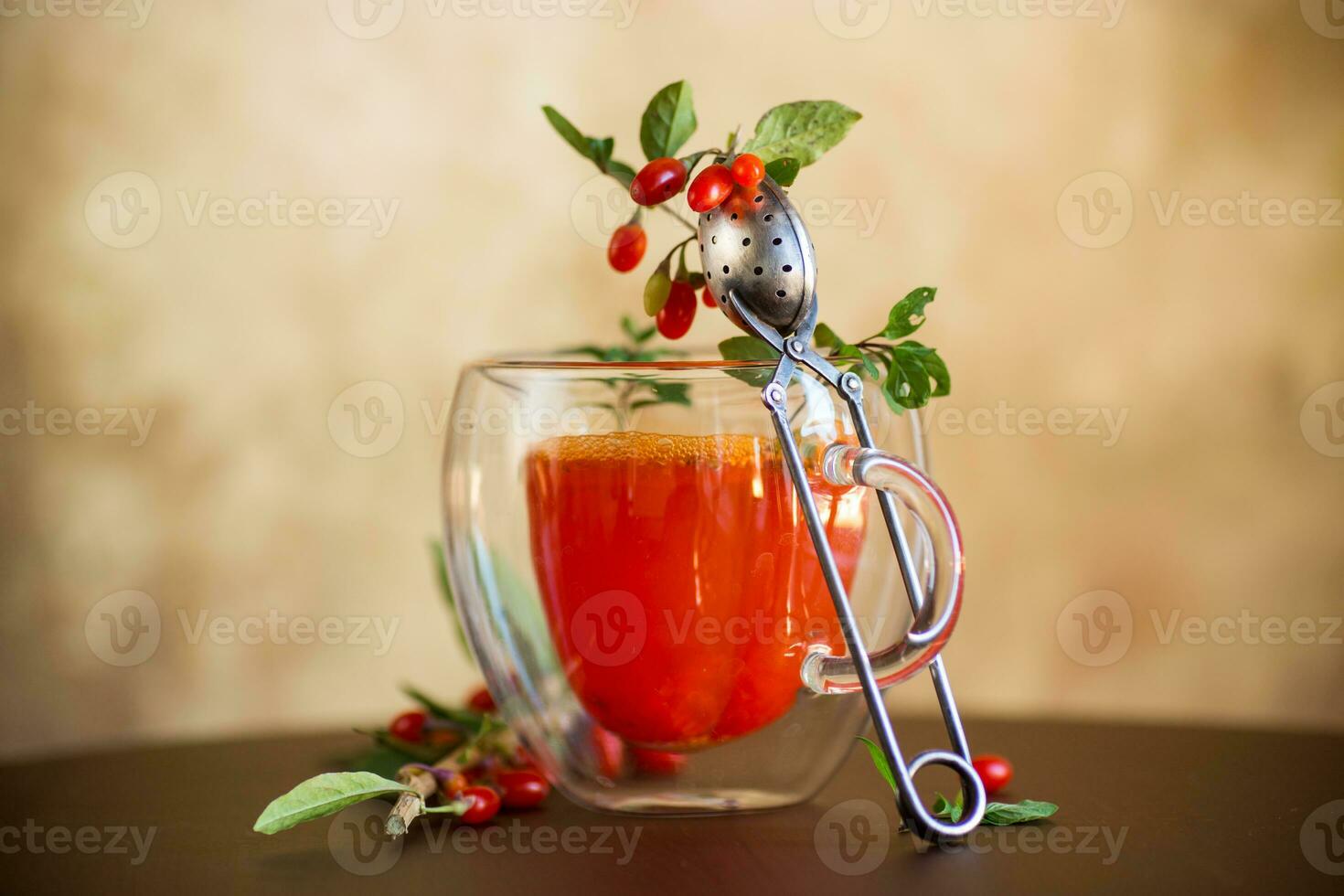 Prepared hot drink from ripe goji berries in a glass cup photo