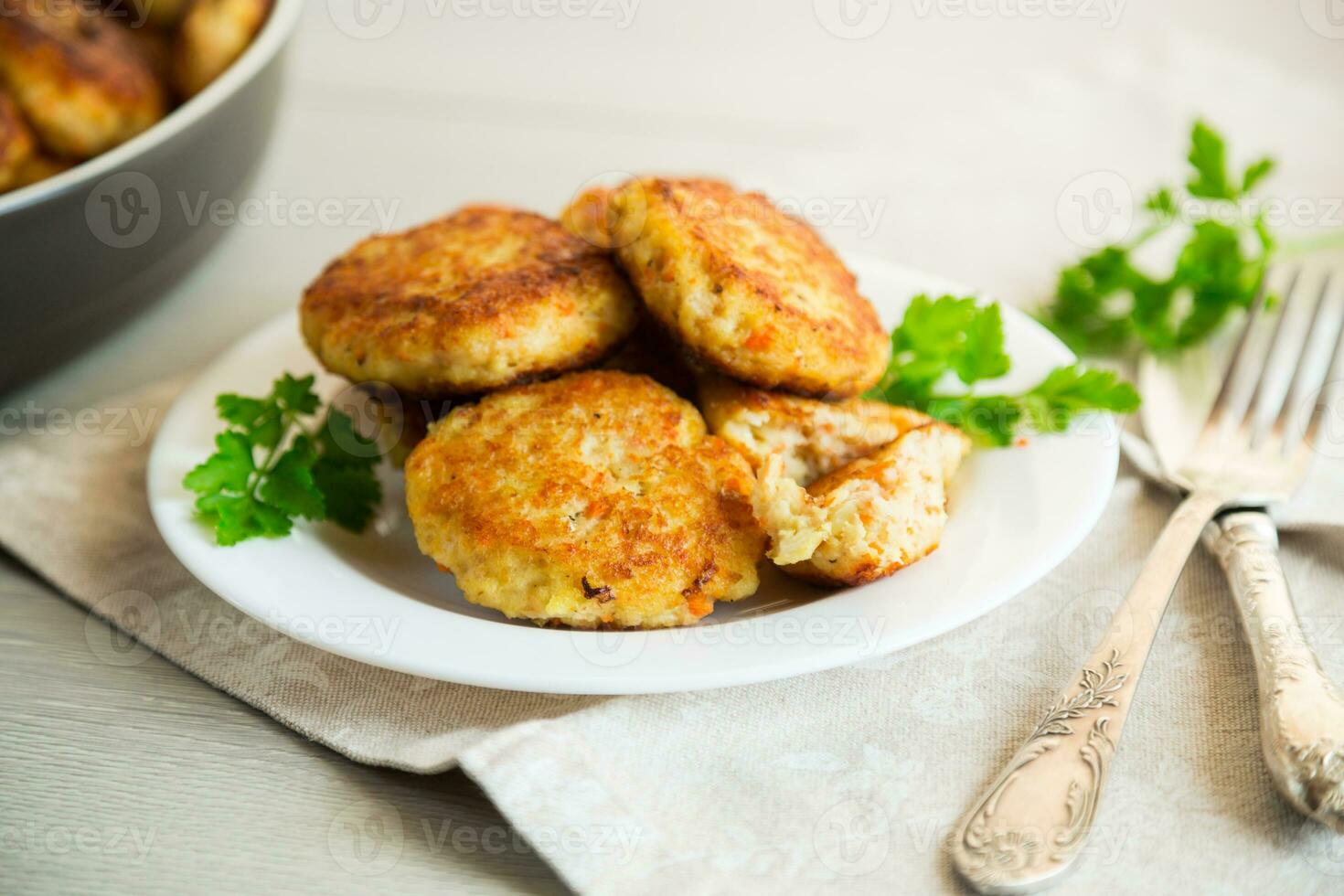 Cooked fried fish cutlets in a plate with herbs. photo