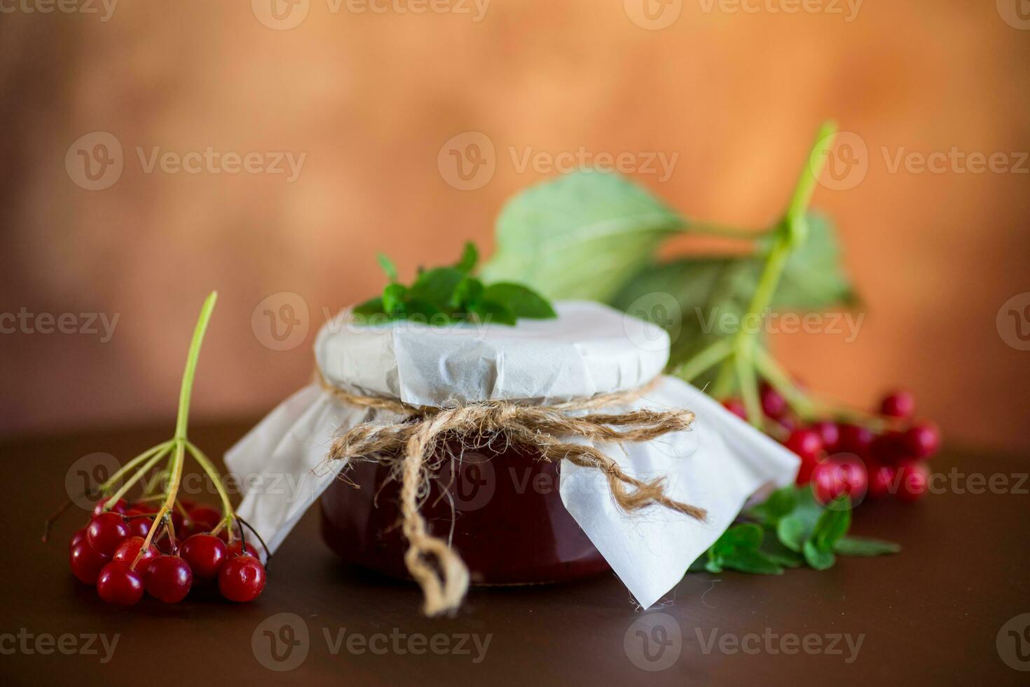 viburnum jam in a glass jar and fresh red viburnum. photo