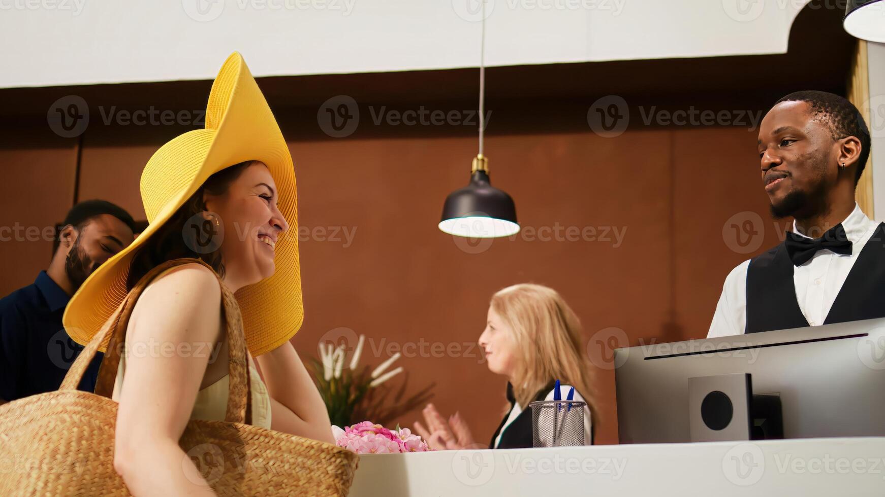 hotel conserje acogedor turistas en vestíbulo, saludo Pareja a frente escritorio a revisión habitación reserva y hacer cheque en. personas en Luna de miel disfrutando tropical verano día festivo. Mano disparo. foto