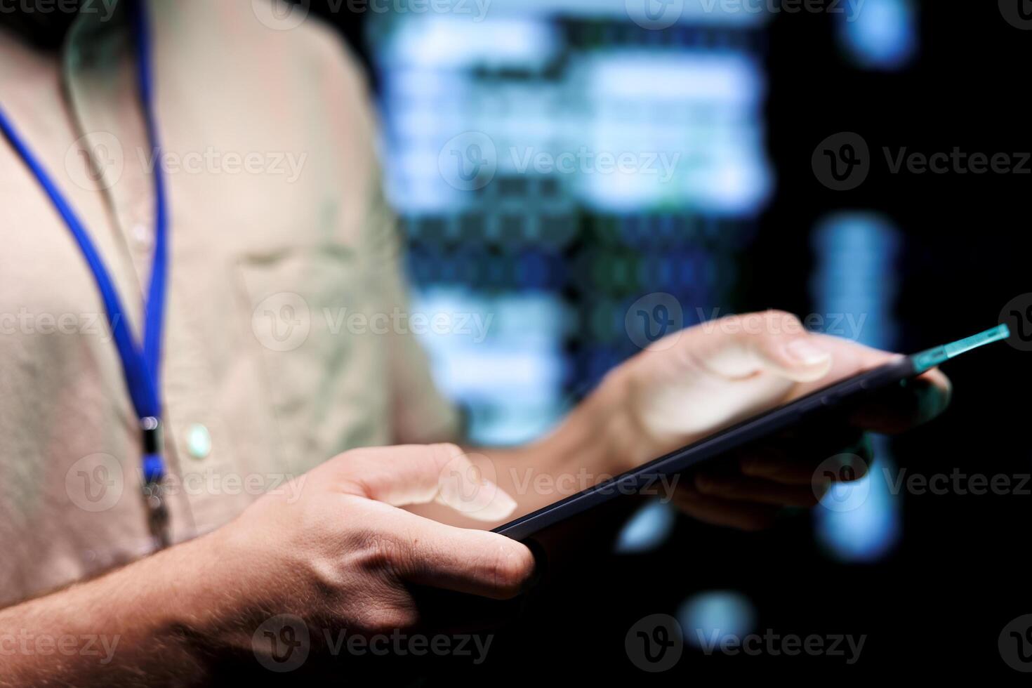 Precise mechanic doing routine system scan, typing data on tablet of needed repairs in blade servers housing advanced data storage equipment supporting complex computational operations, close up photo