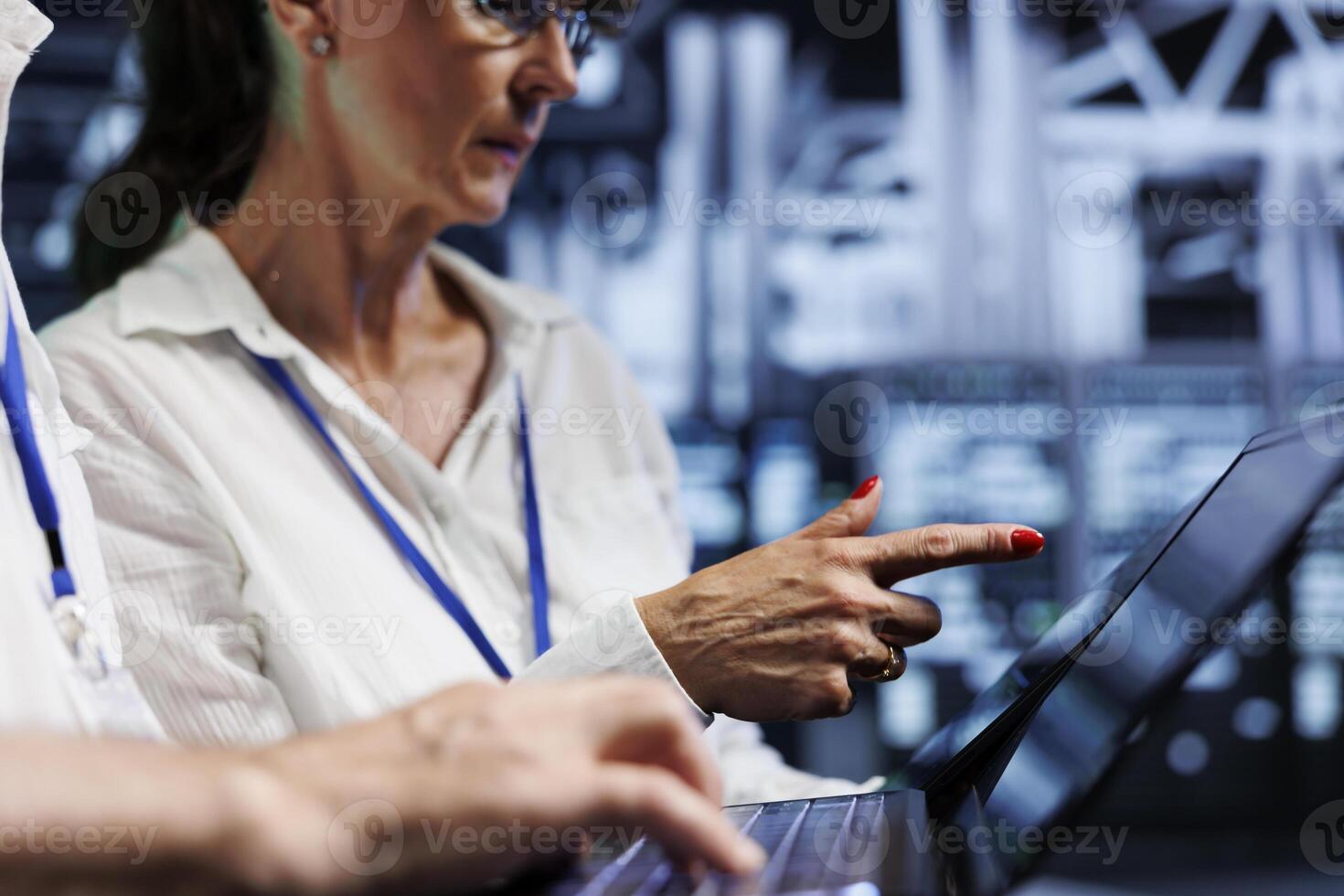System administrators performing diagnostic assessments on supercomputers to detect problems with server farm units. Experts crosschecking checkup lists, looking for potential system hazards photo