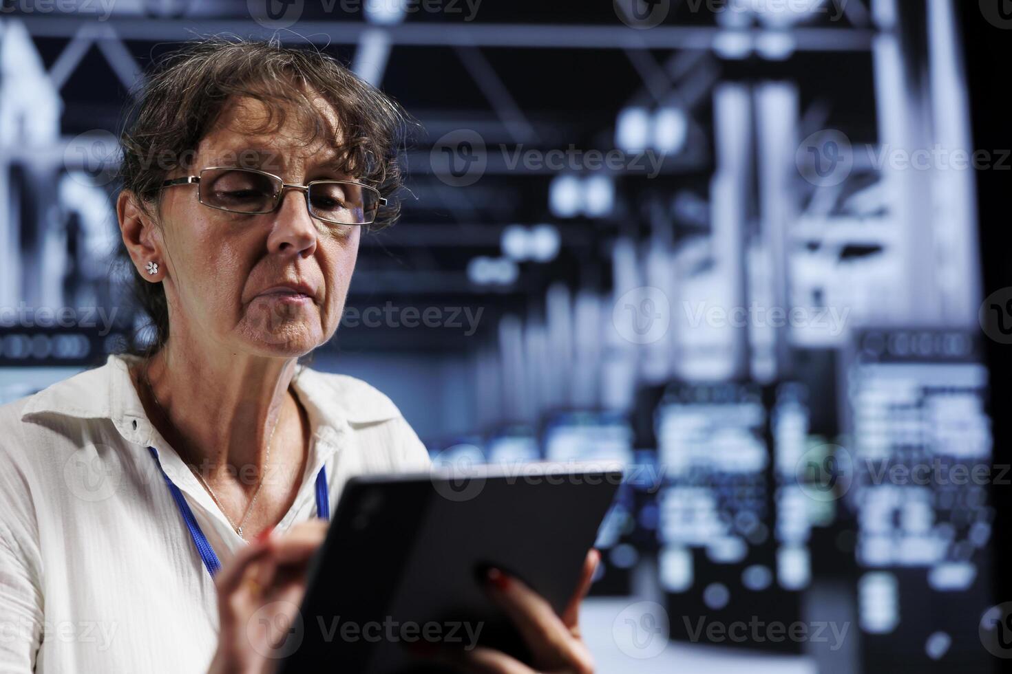 Elderly IT programmer using tablet to assess server cybersecurity dangers arising due to unsecured network connections. Supervisor ensuring high tech facility is impenetrable by ddos attacks photo