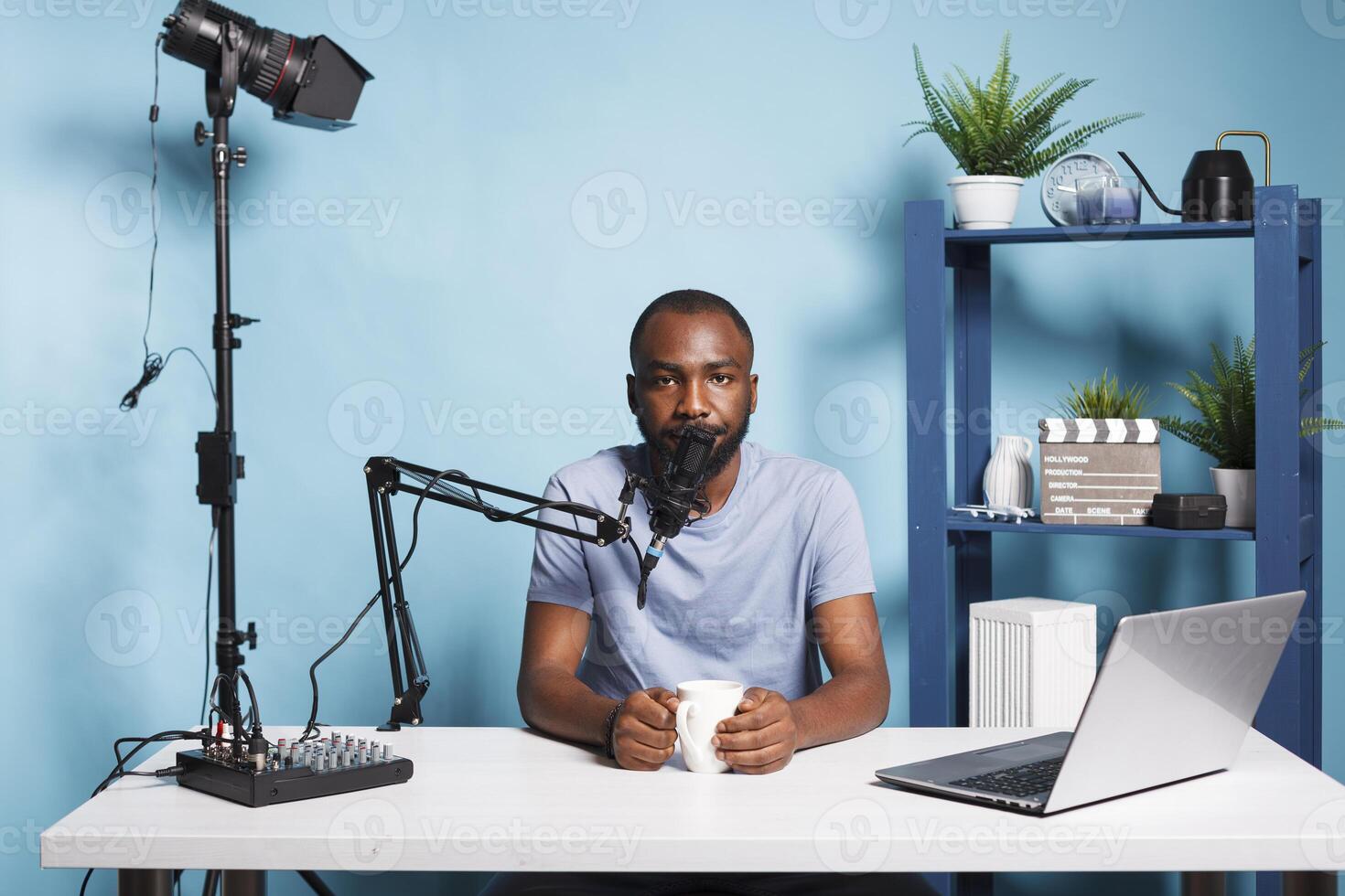 Blogger live streaming and broadcasting online for vlog video channel while looking at camera. African american man vlogger creating digital content and speaking on camera photo