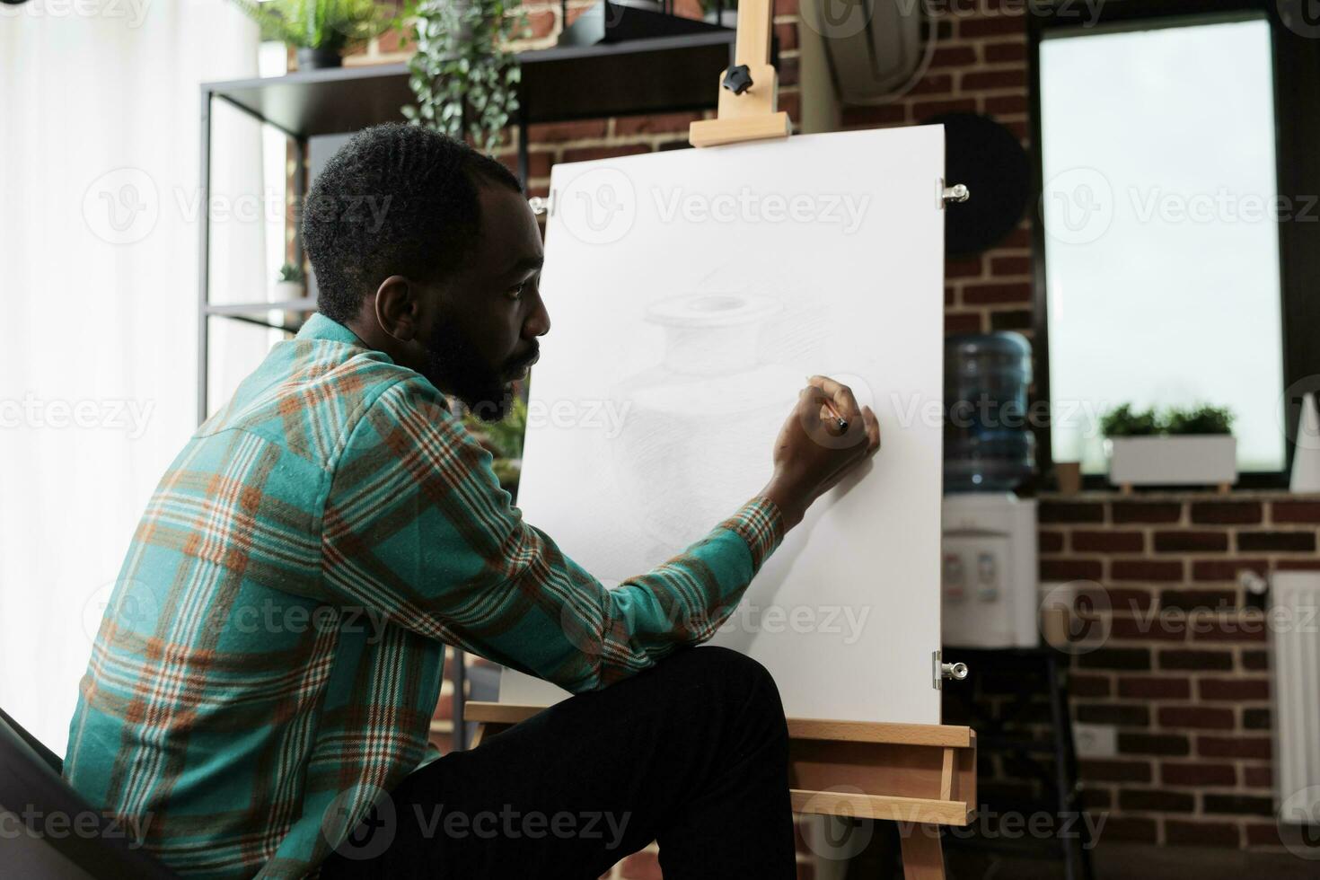 joven africano americano chico expresando él mismo mediante arte, asistiendo dibujo clases, masculino estudiante mejorando dibujar habilidades. talentoso artista sentado a caballete creando obra maestra en lona foto