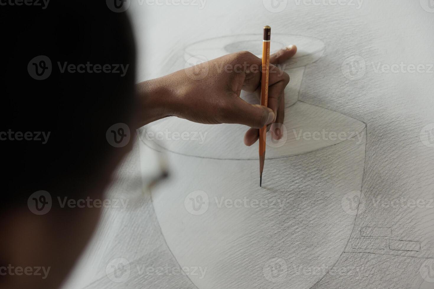 Close up of student hand holding pencil practicing sketching techniques while studying at art school, people developing drawing skills. Artist creating sketch, creating artwork photo