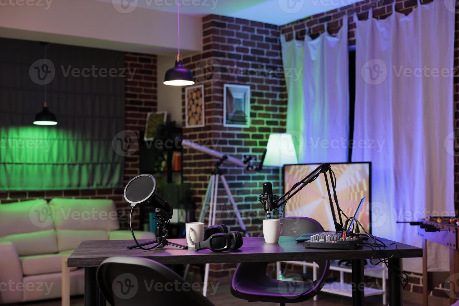Empty desk in home production studio with podcast equipment technology recording sound for social media channel production. Live broadcasting space in living room with neon lights photo